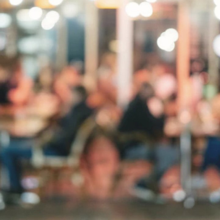 A crowded room at night, out of focus, a party in full swing